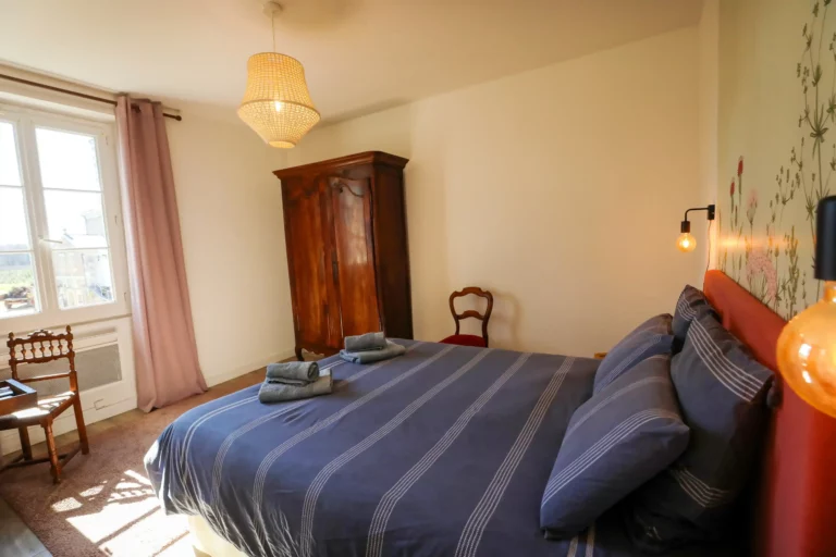 Chambre cosy à la Closerie avec lit double, armoire en bois et lumière naturelle