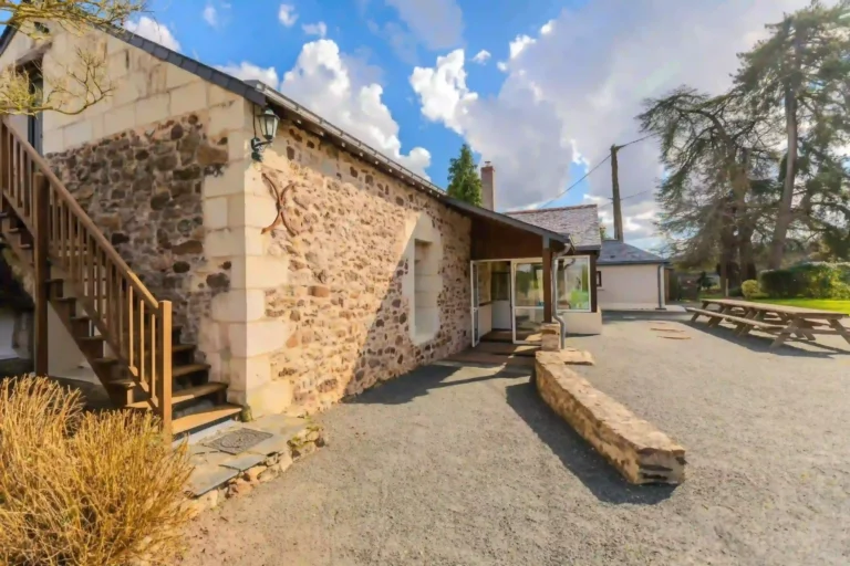Entrée en pierre des Demeures de Bois Brinçon avec escalier extérieur en bois et espace convivial